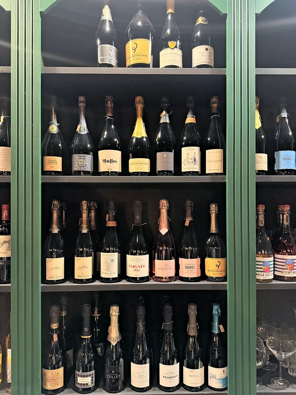 Lo scaffale dello champagne con bottiglie di diverse maison